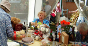 A woman sat at a table, with raffle prizes